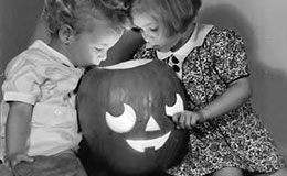 Two children looking into jack-o-lantern, 1938.