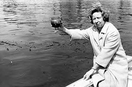 Betty Klaric holding water sample from Cuyahoga River.